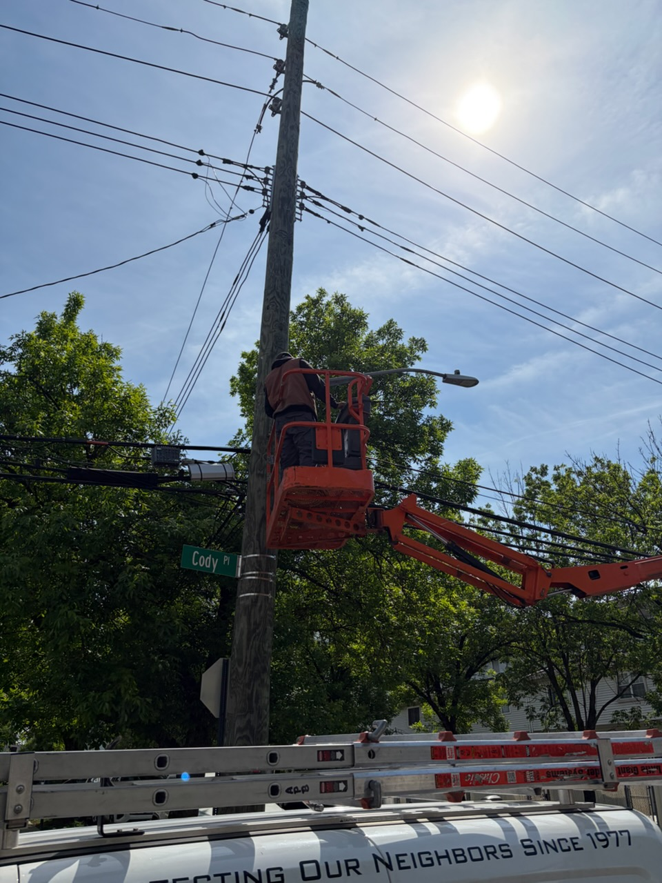 APB technician in a bucket lift installing a security camera on a utility pole