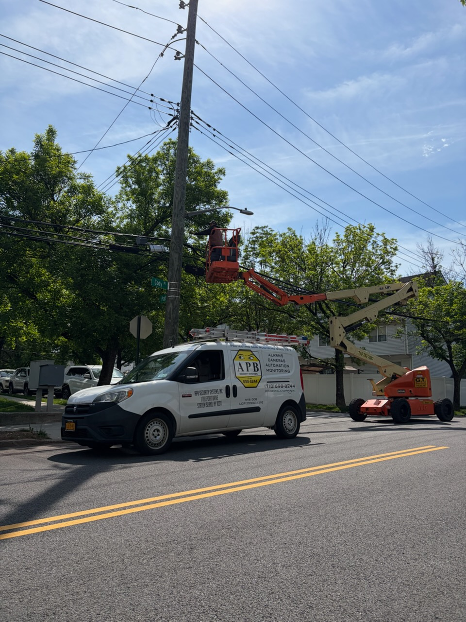 APB Security van and bucket lift at a pole-mounted camera install